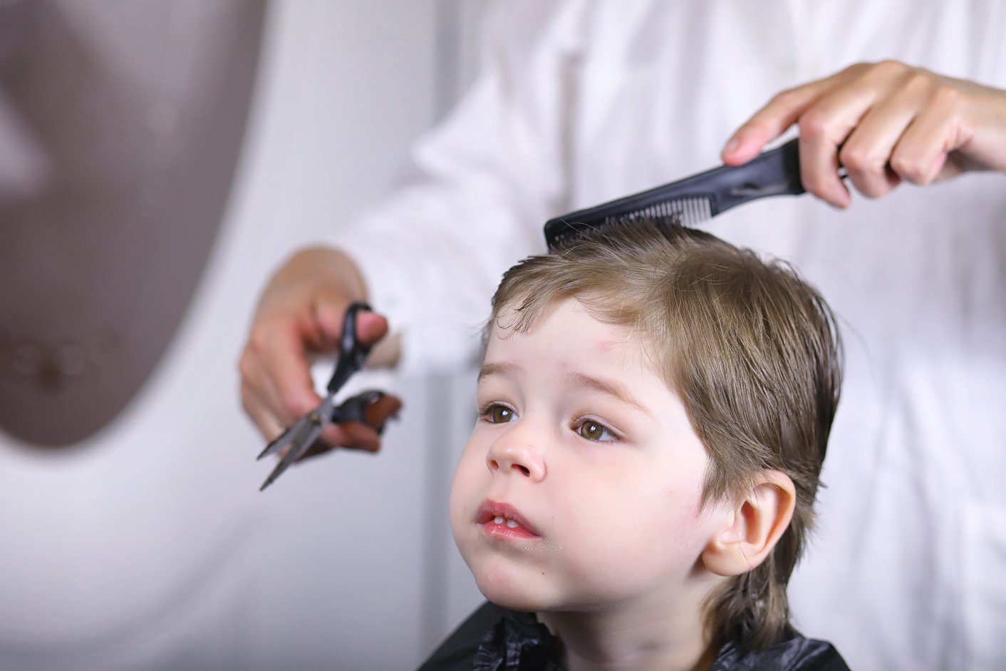 Hairdresser Cutting Hair of Kid